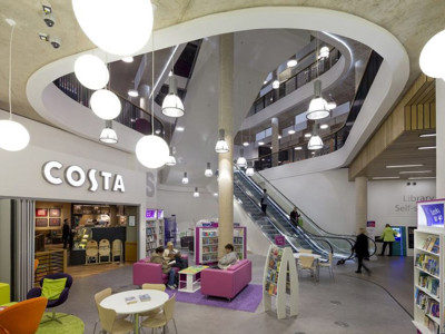 Bright purple and green lounge seating beside browsing shelves in the open-plan library floor at Southwater Library