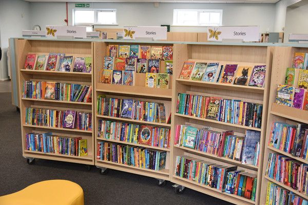 Curved shelving units filled with colourful children's books and face-out displays in a young readers' browsing space at Birtley Library
