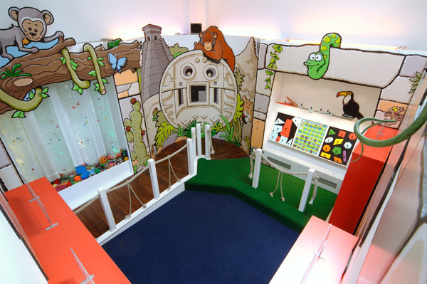 Colourful animal-themed murals and a soft play area with a green carpet at Wentworth Primary School