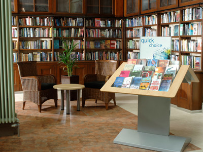 Wicker chairs and a small table beside a themed book display at Wimbledon Library
