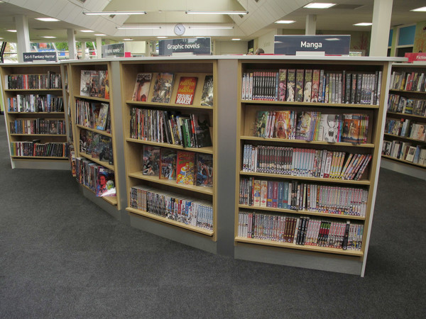 Curved shelving units filled with graphic novels and manga titles in a browsing space at Newark Library