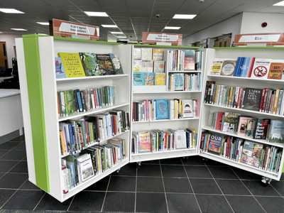 Curved shelving units displaying a variety of health and wellbeing books at Llanrwst Library