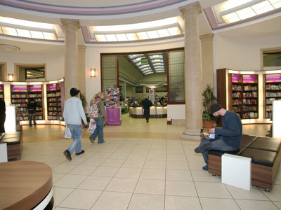 Visitors browsing shelves and seating areas with natural light at Bolton Central Library