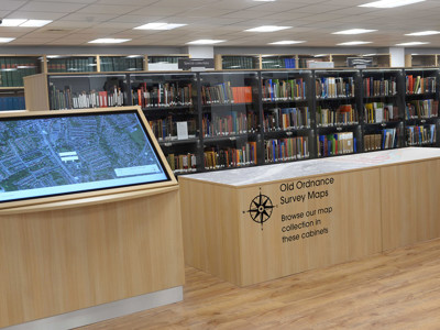Interactive touchscreen display and wooden map cabinets in a digital browsing area at Gateshead Archive Library