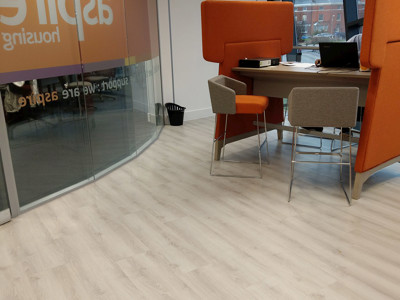 Orange high-backed seating and a collaborative work table in a modern workspace at Newcastle-under-Lyme Library