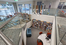Library social space design — comfortable reading nook and seating area encouraging longer library visits