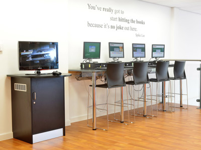 High tables with black stools and computer stations for digital access at Risca Palace Library