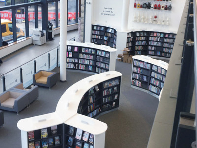 Curved white bookcases filled with books in a public library browsing area at Danum Library