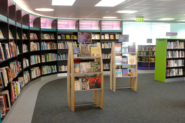 Curved shelving units displaying face-out book titles in a browsing area at Yate Library