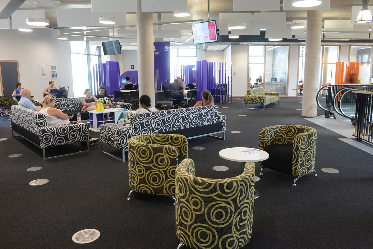 Circular patterned lounge chairs and modular seating in a public library browsing area at Southwater Customer Services